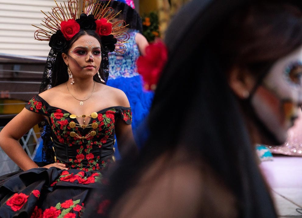 Women in elaborate dresses and day of the dead face paint