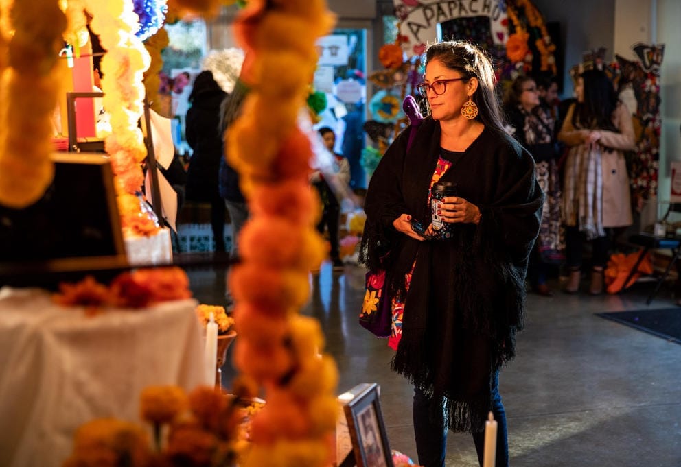 A woman is illuminated by evening sun, surrounded by colorful decorations