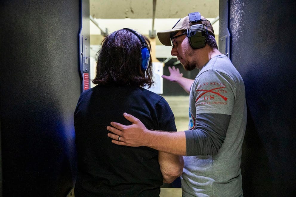 John Abbitt instructs Melissa Elmer, 68, as she learn how to shoot a gun for the first time at West Coast Armory in Bellevue during a Pink Pistols range meetup on May 18, 2019. Melissa recently got her concealed pistol license and came to Pink Pistols with her wife to learn how to shoot it. Abbitt is regularly involved with gun education in Pink Pistols. “It builds your confidence,” Abbitt says. “You can say ‘you know, I’m good’.” (Photo by Dorothy Edwards/Crosscut)