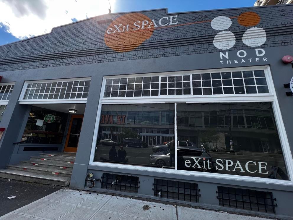 building facade with big windows and the words exit space
