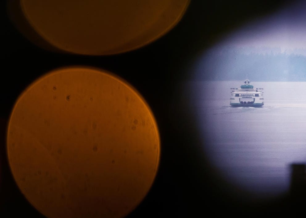 A ferry seen through Christmas lights at Pike Place Market