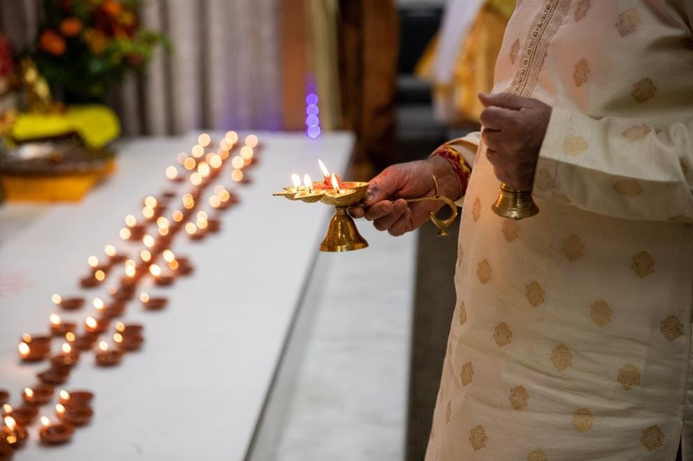 A man holds a lamp in front of a table