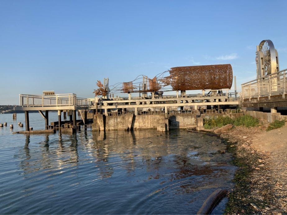 photo of a log sculpture on a river front