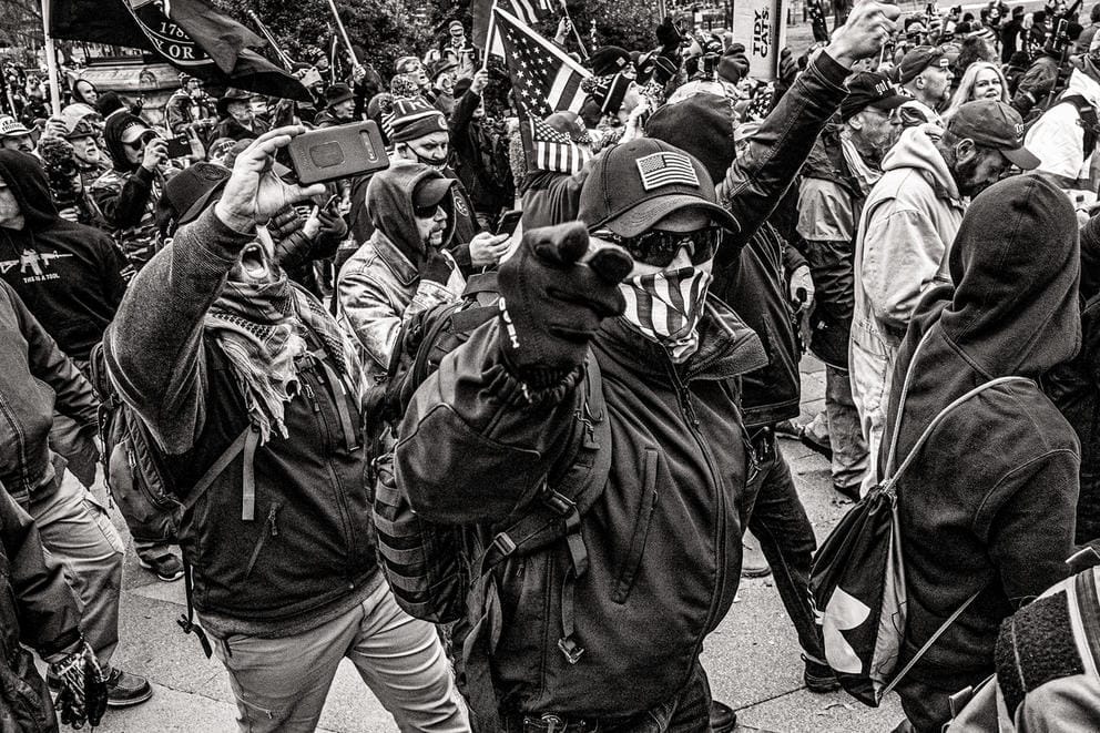 People march, one person points to the camera, photo in black and white