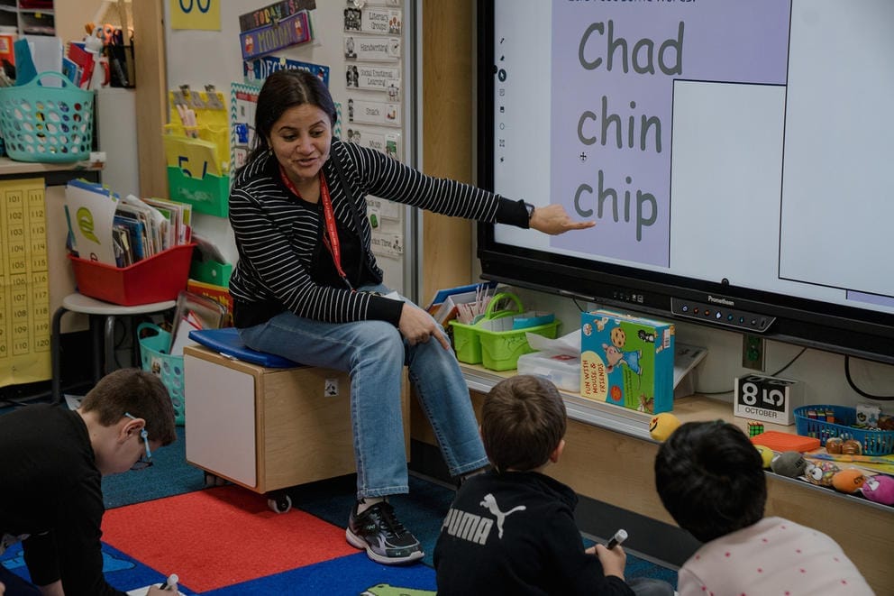 A teaching professional points to words that start with the letters