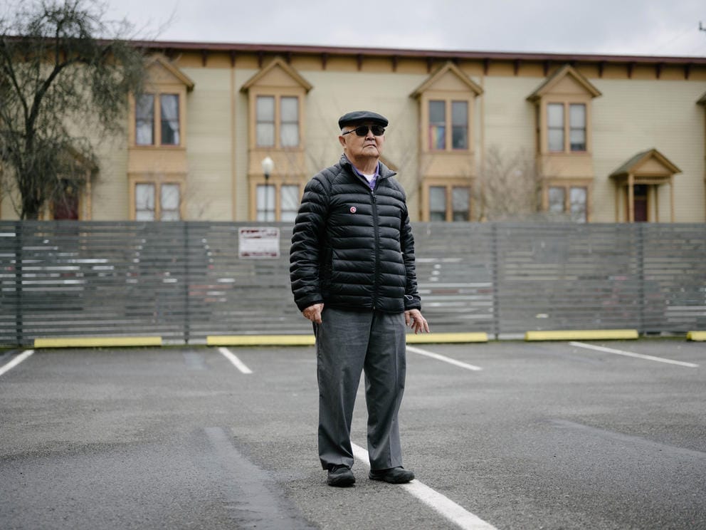 Atsushi Kiuchi poses for a portrait in front of the NVC Foundation Japanese American Memorial Wall