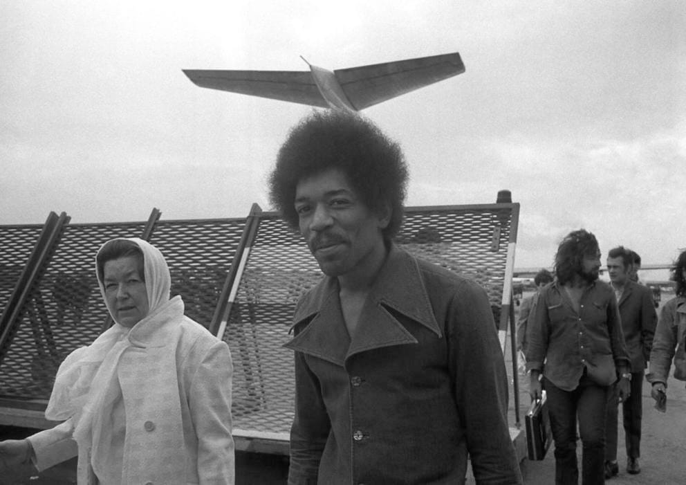 vintage black and white photo of Jimi Hendrix coming off of a plane