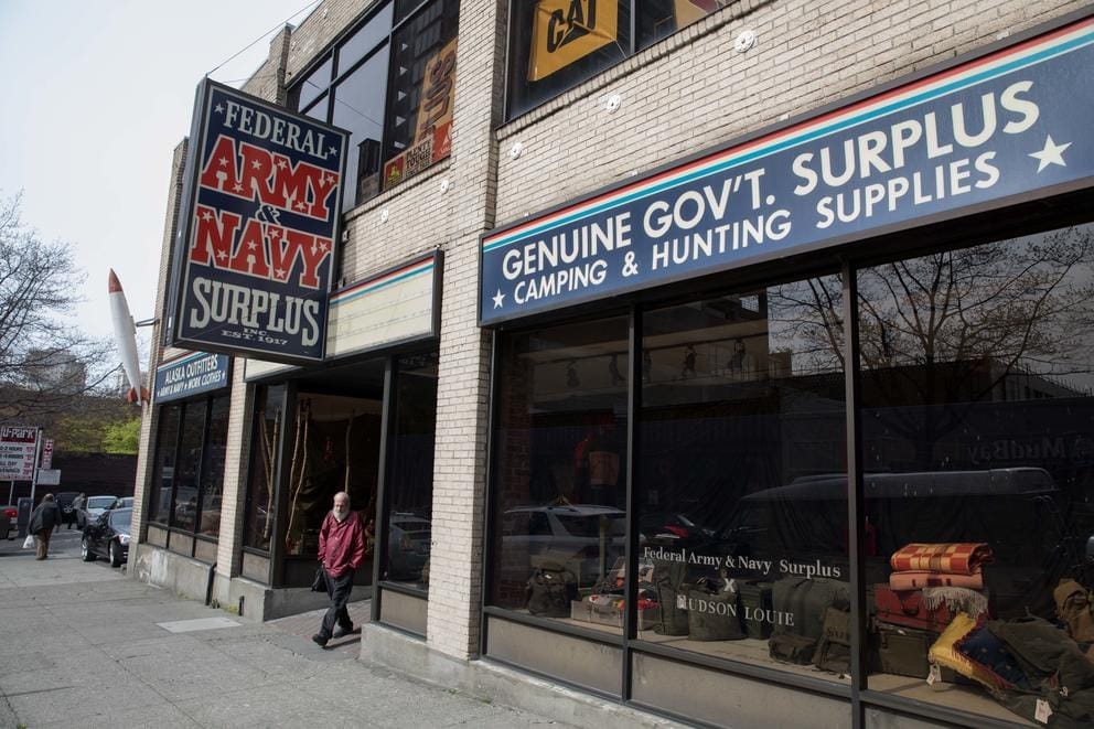 A man walks out the door of the Federal Army & Navy Surplus store in Seattle’s Belltown neighborhood, April 19.