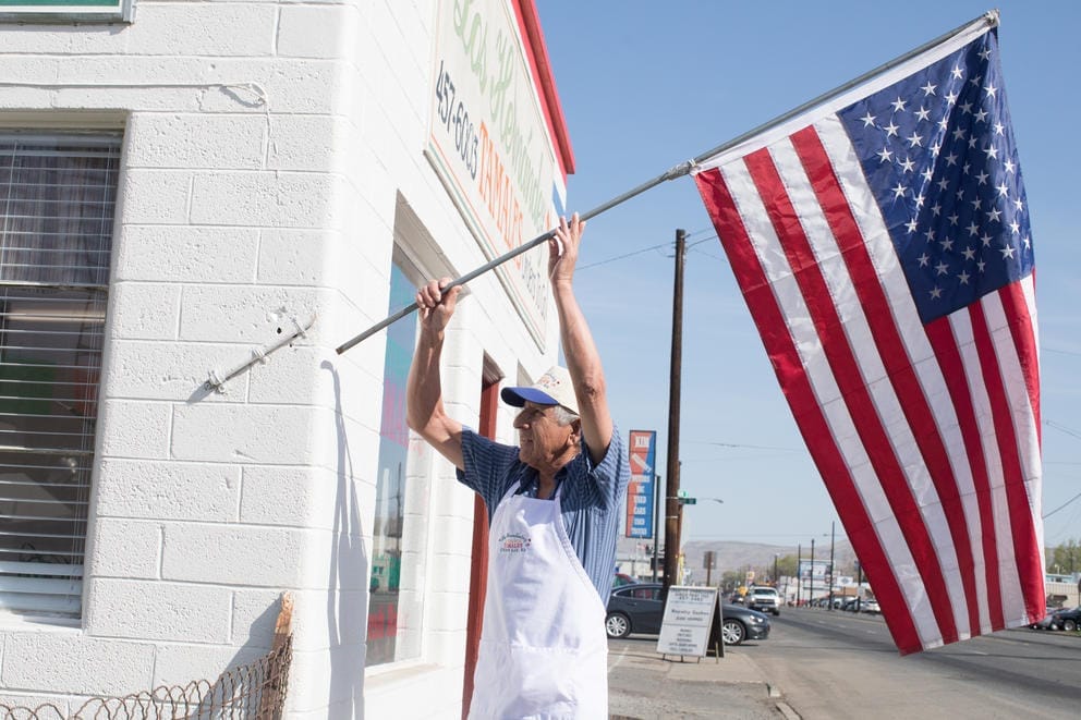 Owner Felipe Hernández hangs an American flag on the exterior of Los Hernández Tamales in Union Gap, Washington, opening the small, award-winning restaurant for yet another day.