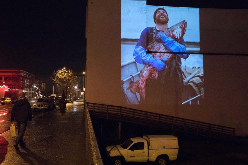 A photograph made by photographer Corey Arnold in Bristol Bay, Alaska, is seen projected on the side of a building along Marine Drive in Astoria.