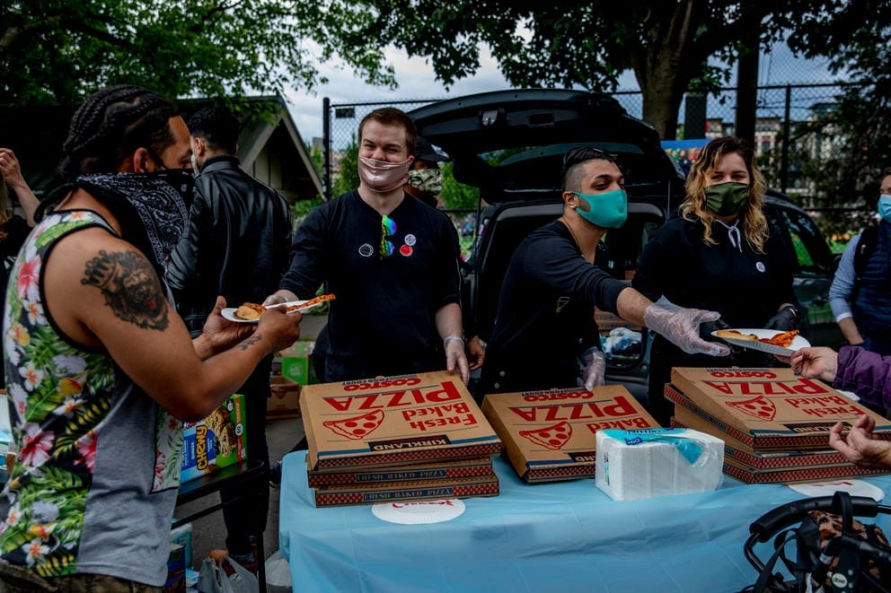 people handing out pizza
