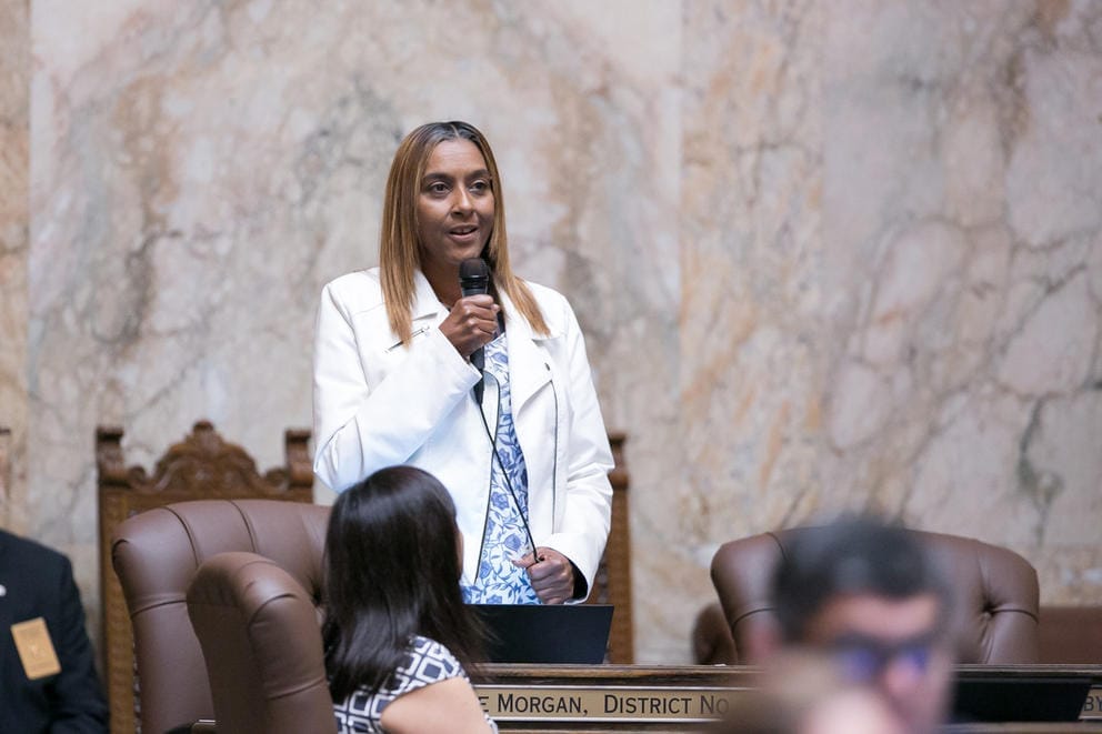 Rep. Melanie Morgan stands with a microphone, speaking