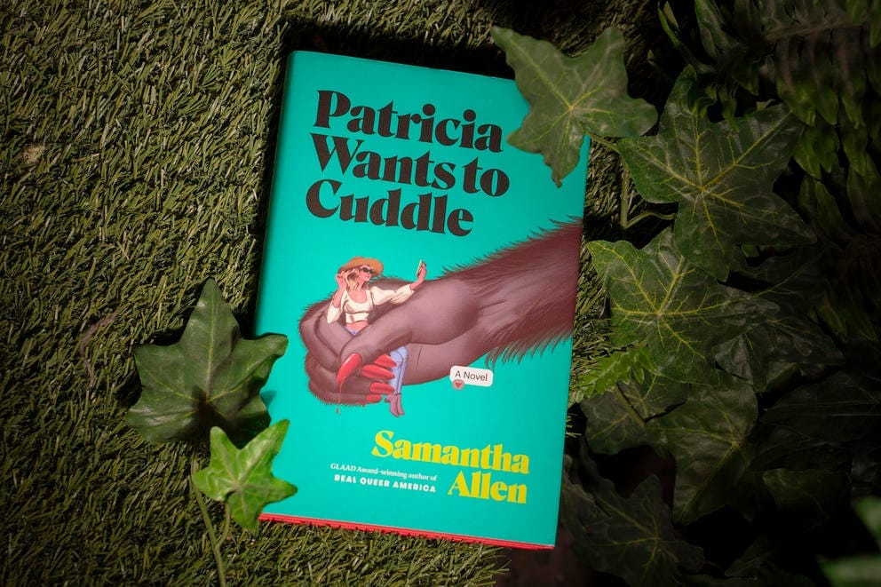 A novel with a green cover featuring a hairy hand holding a woman. The text says in black