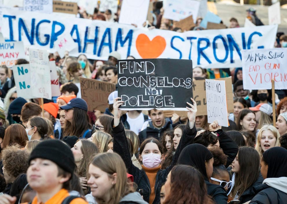 Students hold signs saying