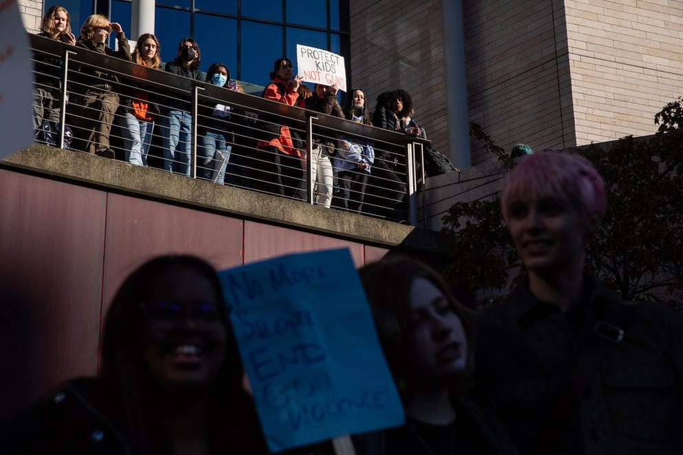 Students stand on two levels holding signs that say such things as