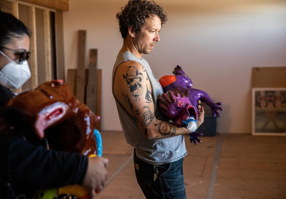 Person holds a purple sculpture in his hands