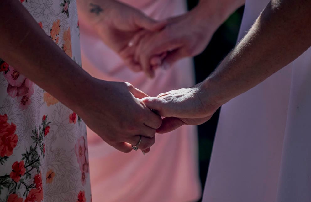 Jessica Johnson and Maia Sage hold hands