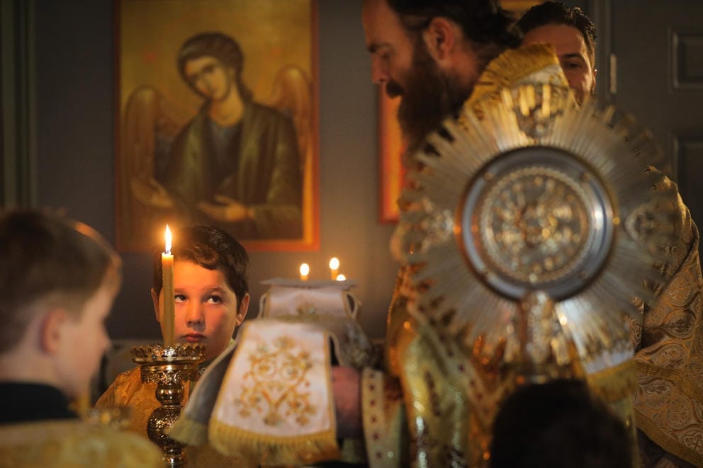 A close up of altar boy as he looks up at Father David Sommer