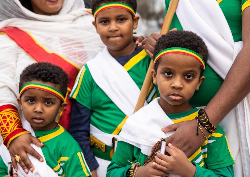 A close up of three boys wearing green and white