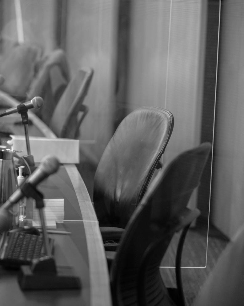 empty chairs behind the city council member's desk at city hall