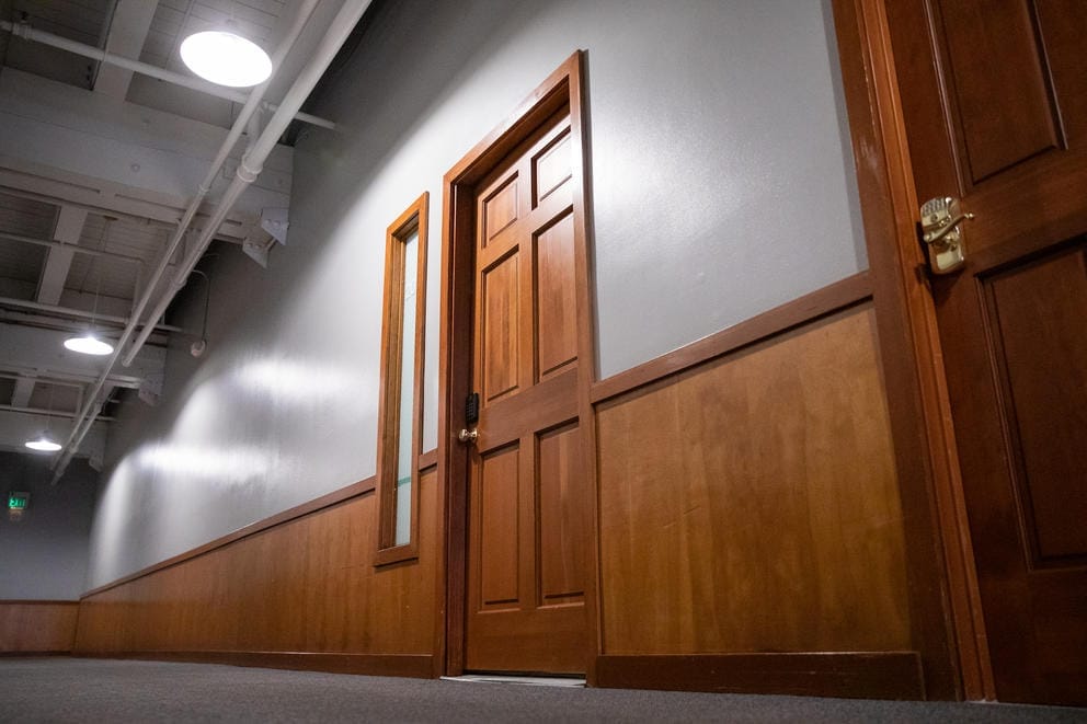 A wooden door in an office building once occupied by a ticket-selling business