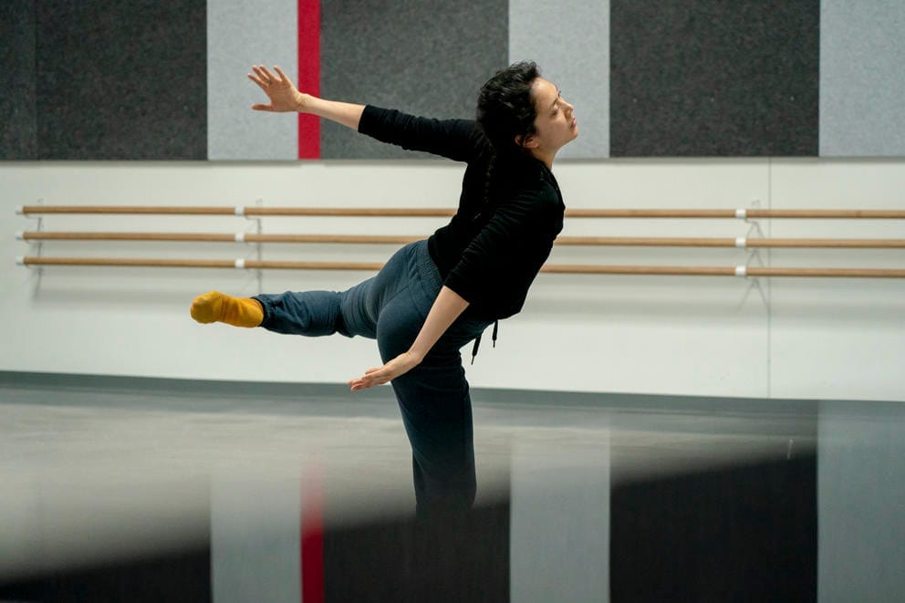 A dancer twirls with one leg up behind her and her arms out to her sides