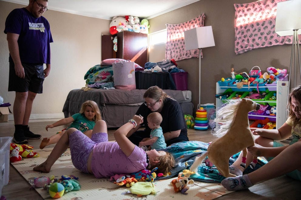 The Blackledge family hangs out in the girls’ room at Neighborhood Apartments