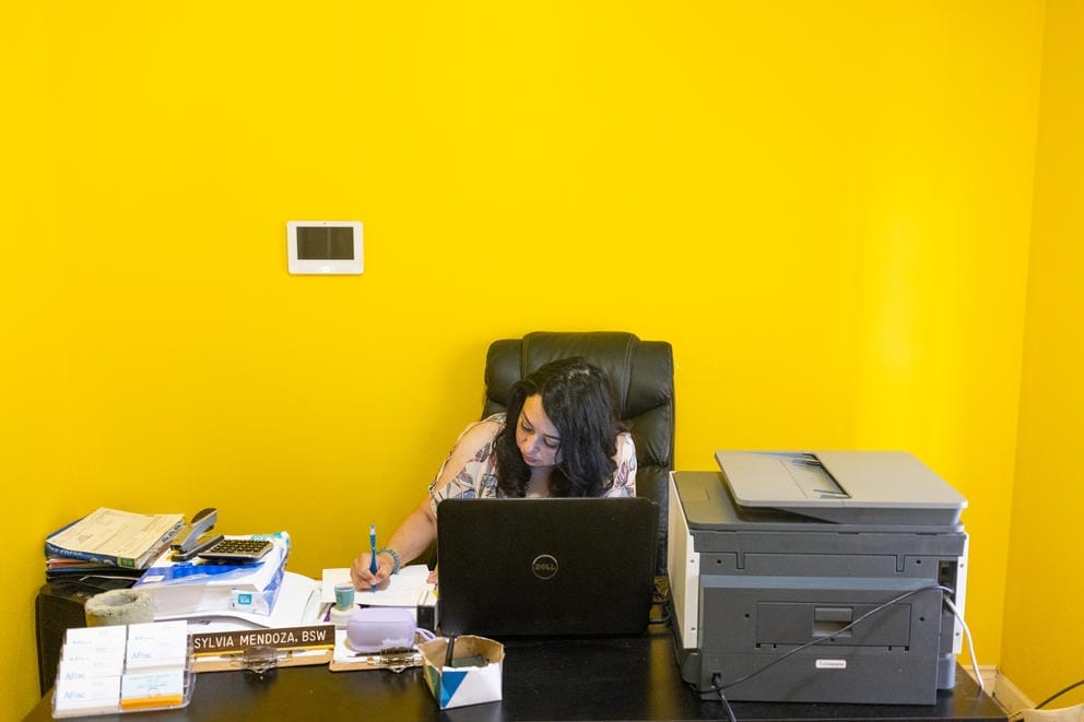 Silvia Zarate writes notes in her home office