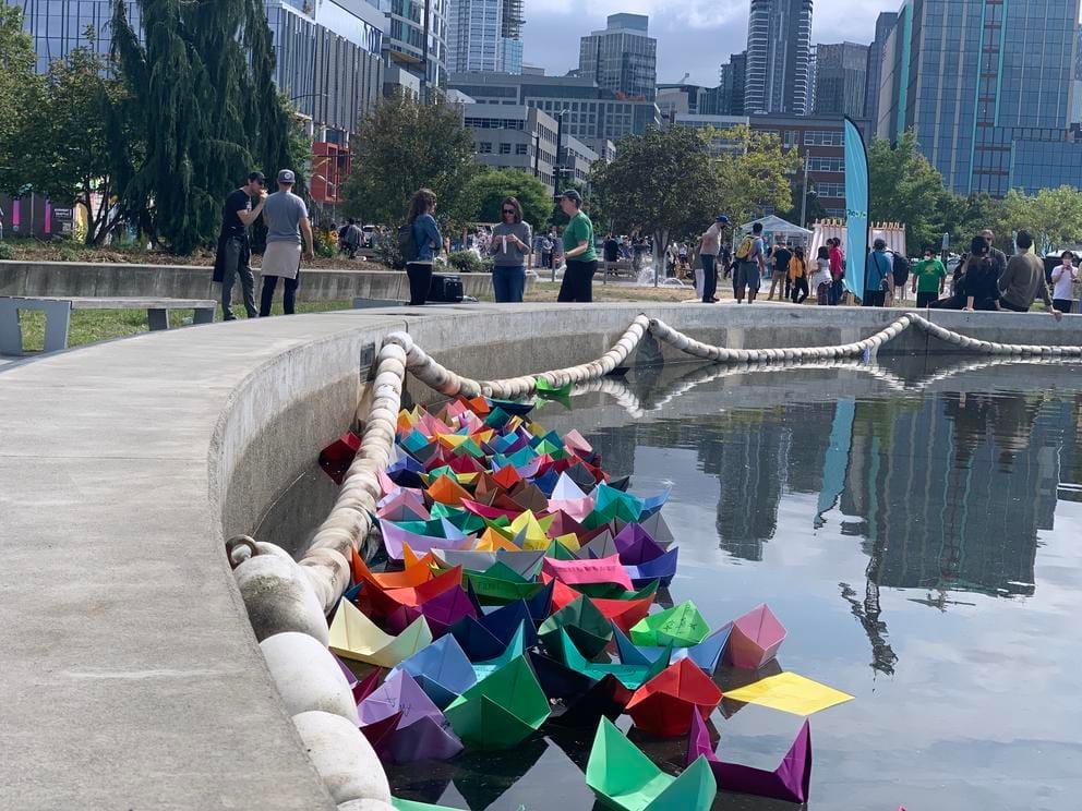 photo of colorful paper boats in a pond