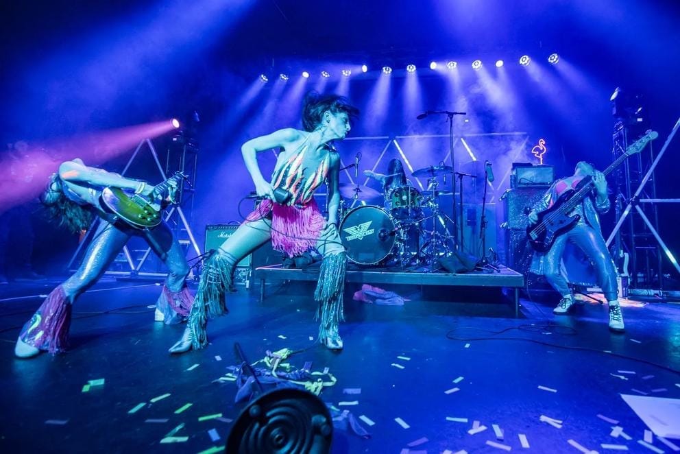 a purple-hazy shot of a band performing on stage