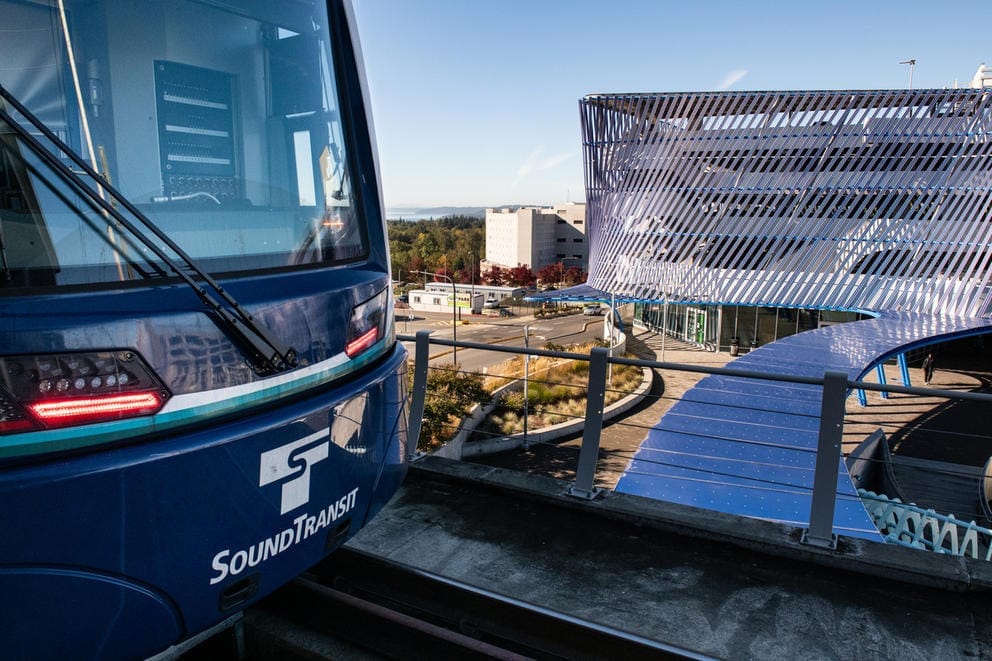 A light rail train arrives at a platform in Angle Lake
