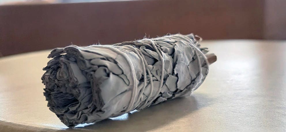 A bundle of sage is on a table.