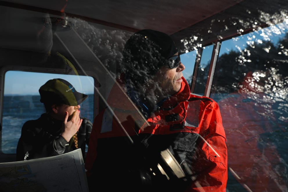 Dive team members are seen though the windshield of a boat