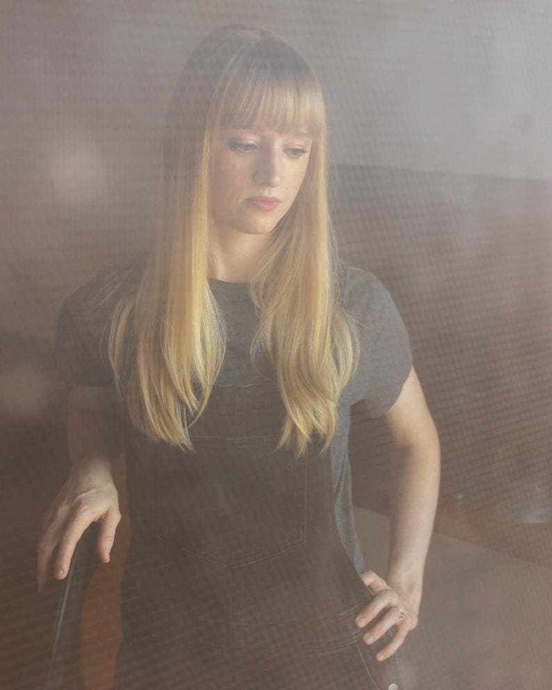 A portrait of Laurel McCallon taken through a gauzy screen door