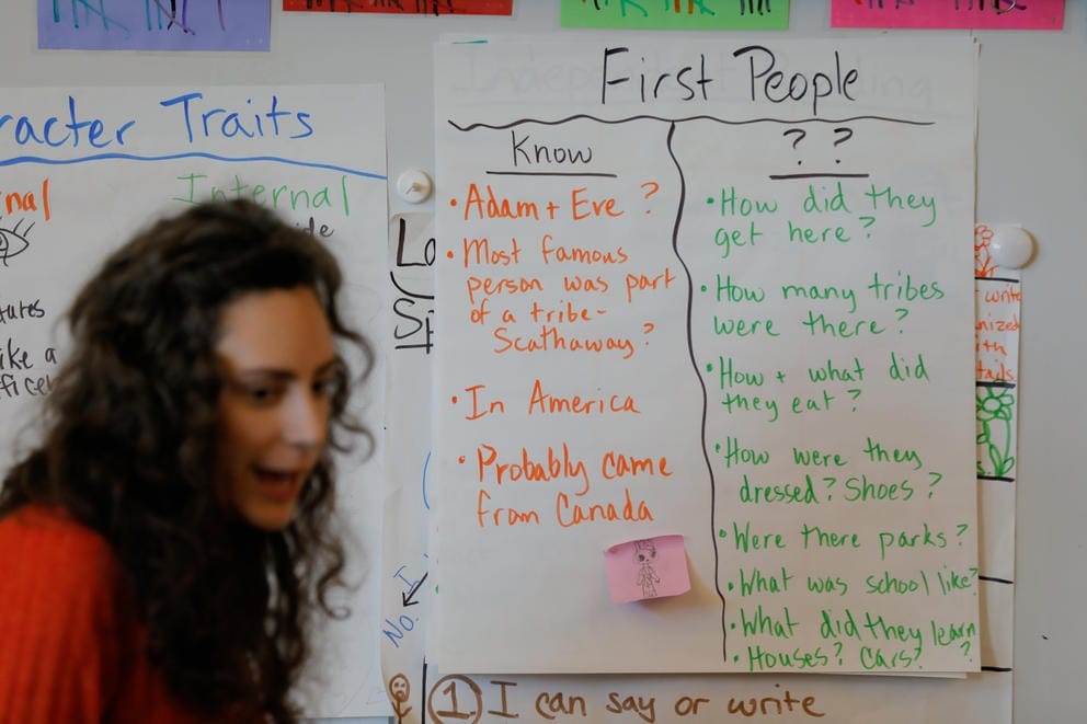 A poster with questions about First Peoples is seen on the board as third grade teacher Chelsea Brassfield teaches her students