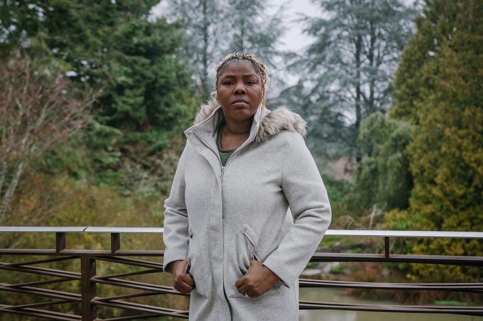 Abie Ekenezar stands in a white jacket in front of trees.