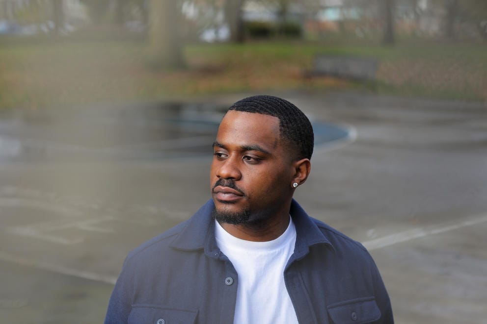 Jelani Howard stands in a parking lot and looks left.