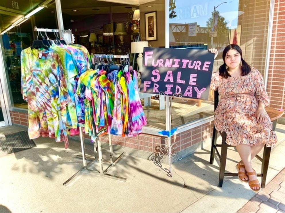 Kit Nelson-Mora sells furniture at their mom’s thrift store, The Storehouse Merchantile, in Omak, Wash., in the summer of 2021.