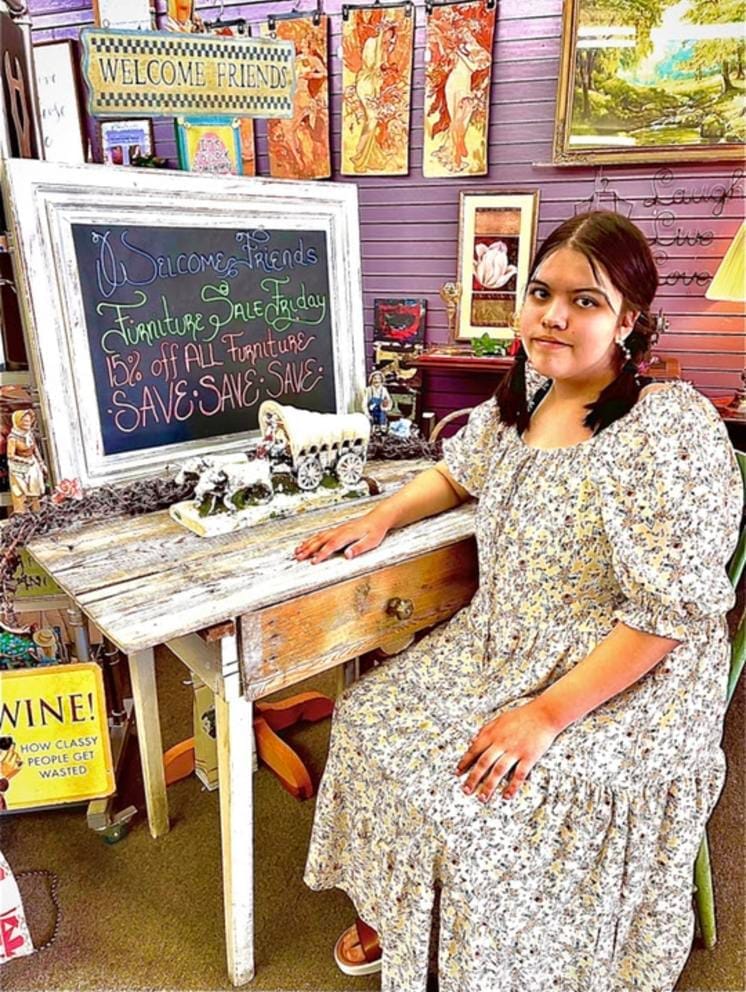 Kit Nelson-Mora sells furniture at their mom’s thrift store, The Storehouse Merchantile, in Omak, Wash., in the summer of 2021.