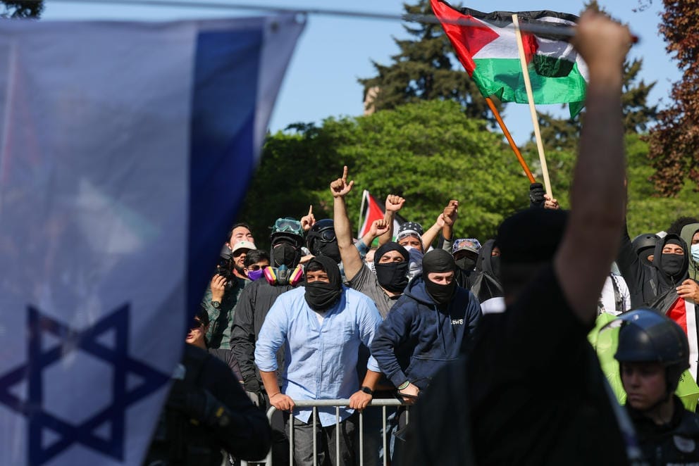 A man from the “United for Israel” march walks back and forth in front of the pro-Palestinian encampment barricade
