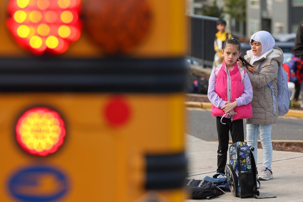 Samya Heyadee, 7, waits for her school bus with a friend outside their apartment complex in Des Moines.