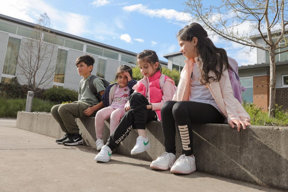 The Heyadee siblings, from left Baheer, 10, Sahaba, 4, Samya, 7, and Sama 9, sit outside of Parkside Elementary in Des Moines, April 29, 2024. The oldest three are students at the school where a majority of their classmates are immigrants and refugees.