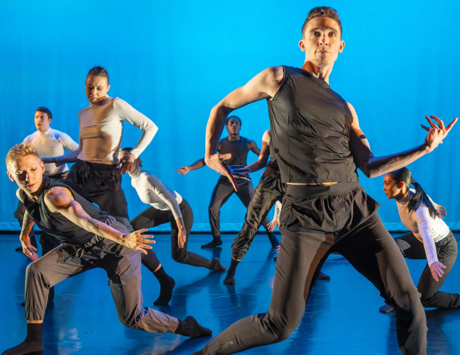 Dancers in front of a bright blue background