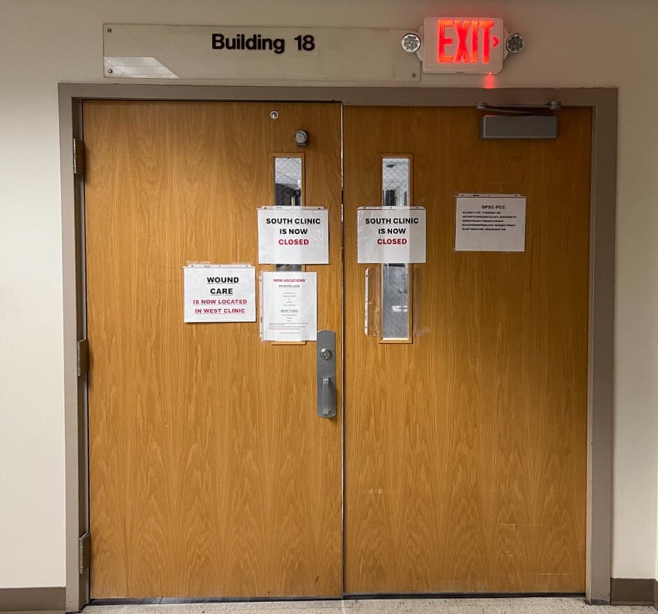 Printer paper closure signs hang on the wooden doors to the South Clinic