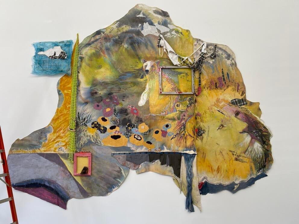 a wall hanging with yellow background and animal faces emerging