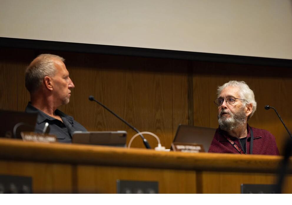 Whatcom County Council members Mark Stremler, left, and Barry Buchanan discuss the investigative report during the meeting.