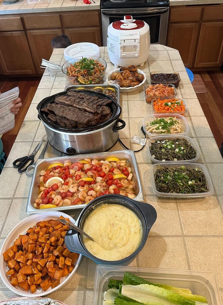 Jane Hong, a Korean-American born and raised in Federal Way, shows her family’s 2023 Thanksgiving spread which included Korean-style beef short ribs called galbi (center in slow cooker), kimchi and other Korean side dishes, and also American dishes like fried chicken, mashed potatoes, and roasted sweet potatoes. (Photo courtesy of Jane Hong)