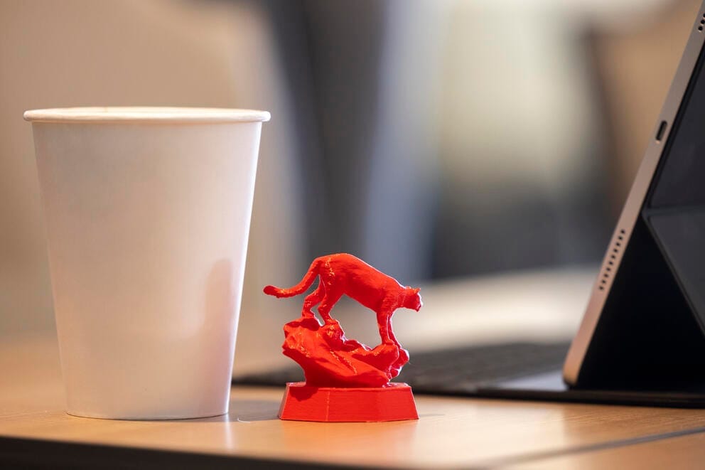 A red cougar figurine stands on the table
