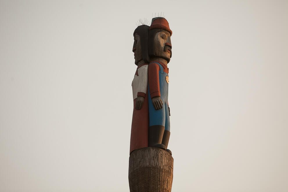 Two people are depicted at the top of a totem pole.