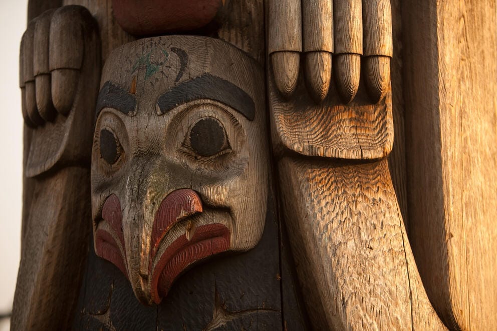 A face is depicted on a totem pole.